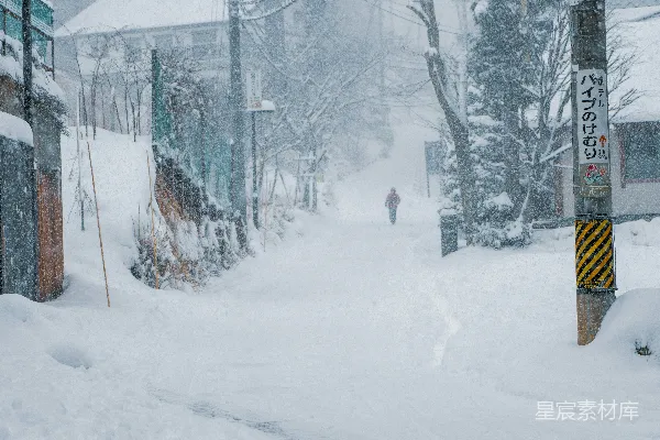 一个人走在覆盖着白雪的街道上