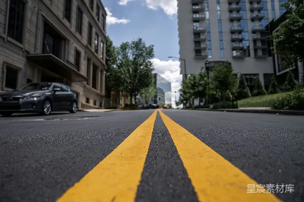 高清摄影 白天，一栋建筑附近道路上的一辆黑色轿车。