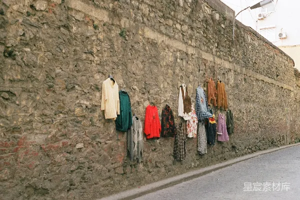高清摄影 一条石墙挂着的衣架上的衣服