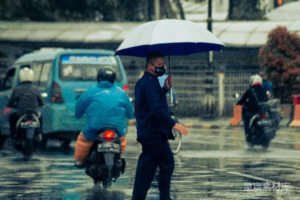 高清摄影 穿着黑色夹克和黑色裤子的男人撑着雨伞走在白天湿漉漉的路上。