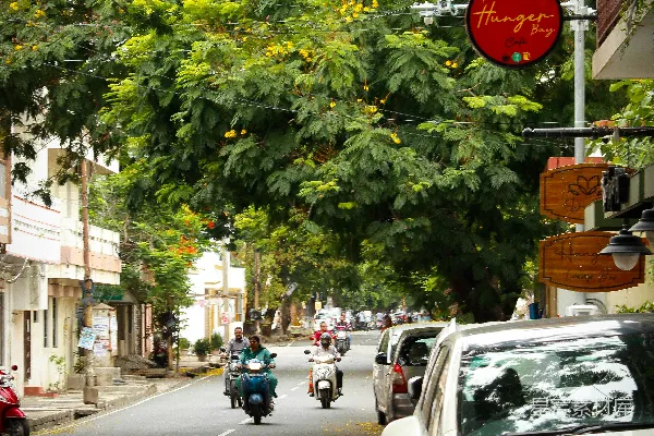 高清摄影 有停着的车、滑板车和标志的街道。