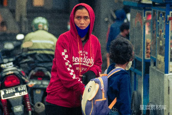 高清摄影 穿红色连帽衫的男人站在穿蓝色夹克的男孩旁边