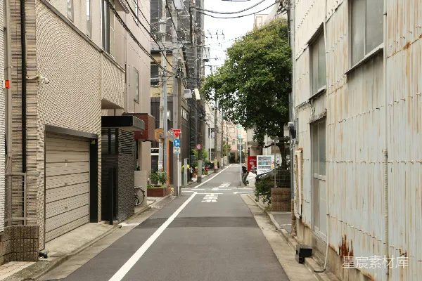 高清摄影 一条窄窄的城市小巷，两旁是建筑物，头顶上是架空的电线。