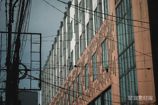 高清摄影 一座高大的建筑物，旁边有很多窗户，紧挨着电线杆。