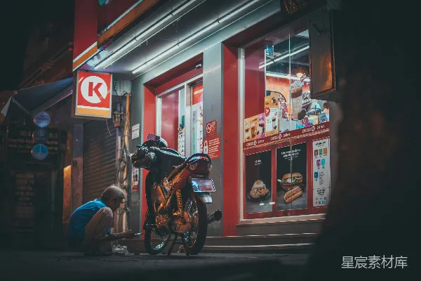 高清摄影 一个男人正在一家商店前面修理摩托车。