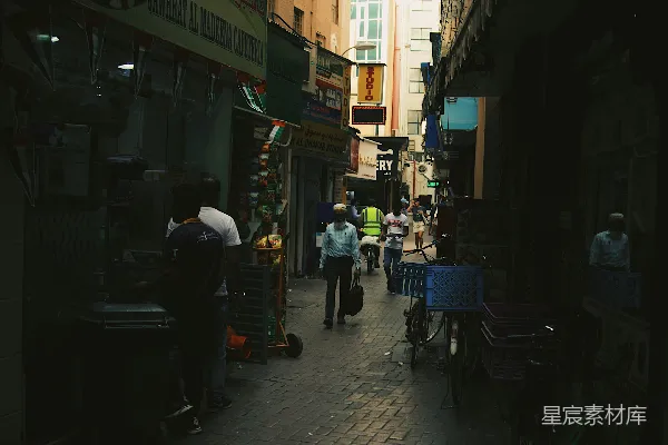 高清摄影 一群人沿着街道行走，街道两旁是高楼大厦。
