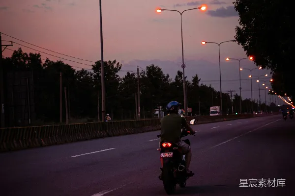 高清摄影 一个男人在夜晚街道上骑摩托车。