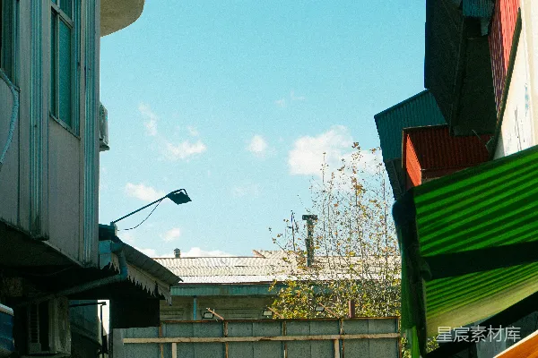 高清摄影 繁忙的街头市场，周围有建筑物，天空湛蓝。