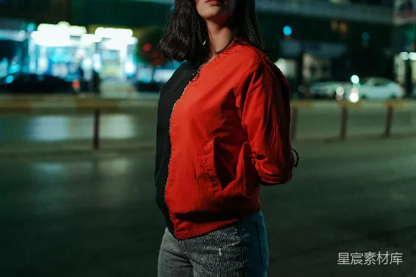 年轻女子站在街上夜间