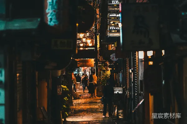 高清摄影 一条狭窄的巷子，晚上人们在巷子里行走。