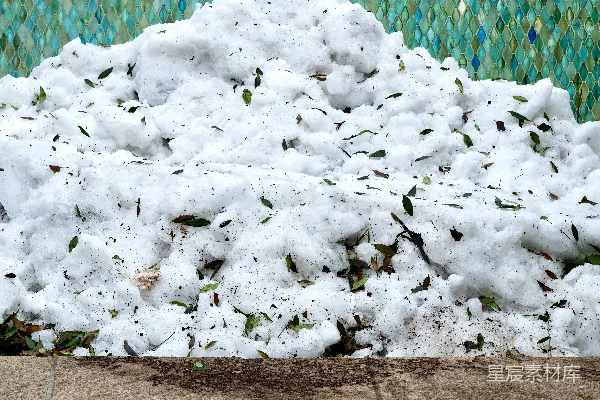 一大堆雪堆积在瓦墙旁。