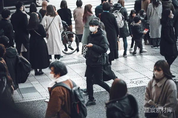 高清摄影 一群人走在高楼旁边的一条街上。