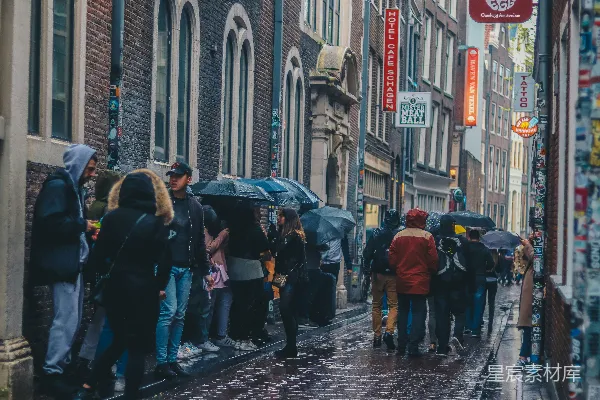 高清摄影 一群人带着雨伞站在人行道上