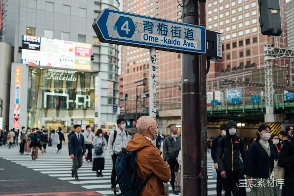 高清摄影 一个男人站在街道拐角处，旁边有一个交通信号灯。