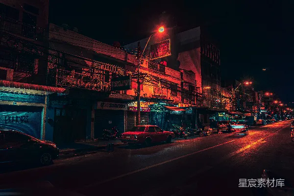 夜晚的城市街道，路边停着汽车。