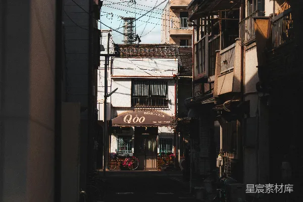 高清摄影 狭窄的城市小巷，两旁是建筑物和头顶上的电线。