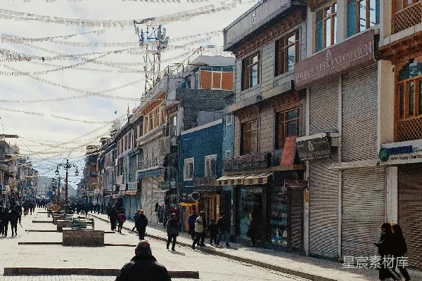 高清摄影 一个人沿着街道走着，街道两旁是建筑物和旗帜。