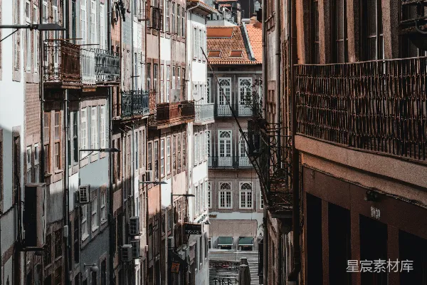 高清摄影 几个行人沿着高楼边上的街道行走。