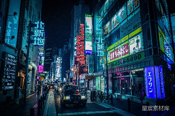 高清摄影 夜晚时分，高楼大厦之间道路上行驶的汽车。