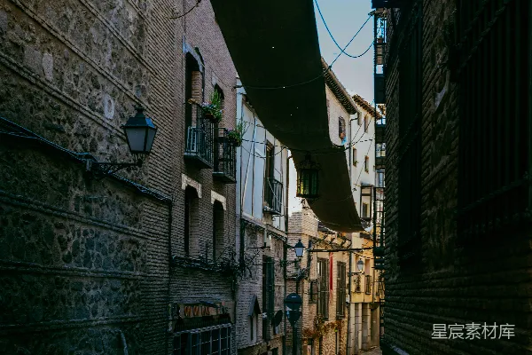 高清摄影 狭窄的古街道，两旁是石砌建筑，上方有布制篷顶。
