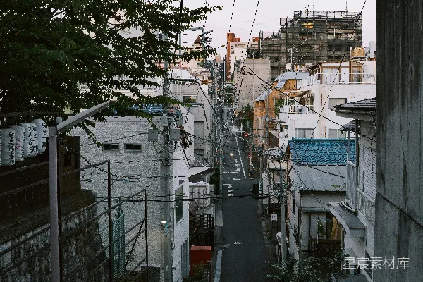 高清摄影 一条陡峭的街道两旁是房屋和电线。