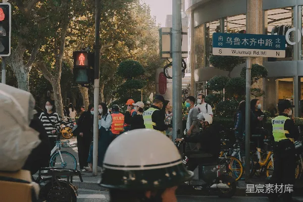 高清摄影 一个男人骑自行车沿着街道经过一个交通灯。