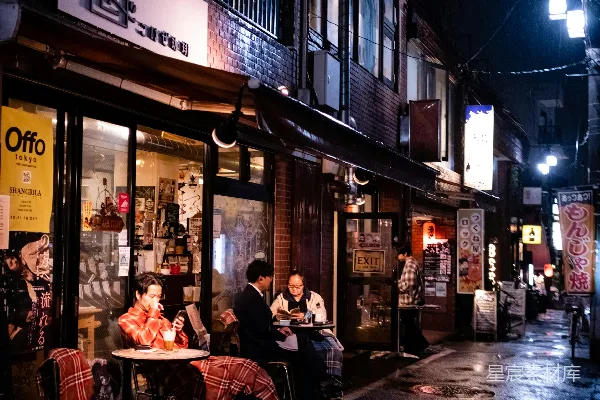 高清摄影 一群人坐在餐厅外面的桌子旁。