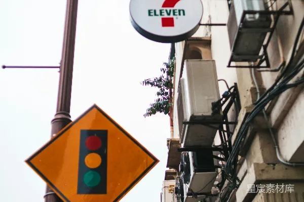高清摄影 7-Eleven标志和街道上的交通信号灯