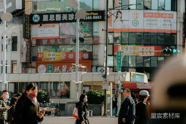 高清摄影 一群人在高楼旁边横穿街道。