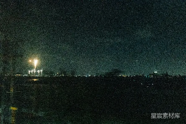 夜晚，烟花在遥远城市 skyline 上绽放。