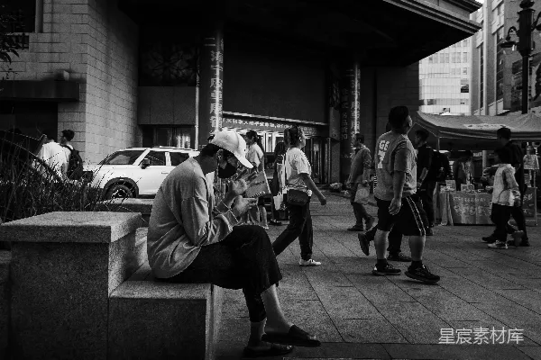 高清摄影 人们在城市里行走时，有人在看书。