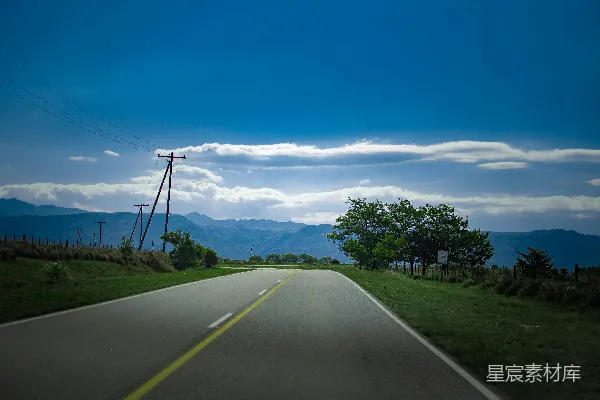 高清摄影 一条两旁有草和树木的道路