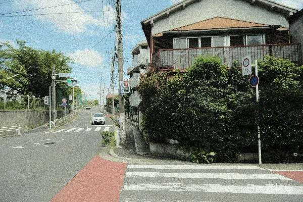 高清摄影 一辆汽车沿着街道行驶，旁边有一座高楼。