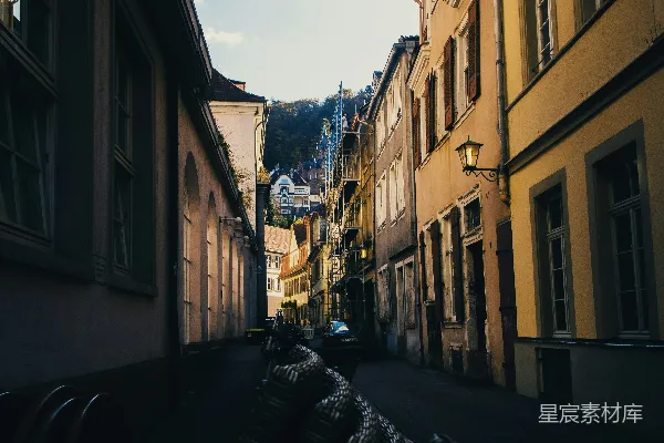 高清摄影 狭窄的街道，两旁是建筑，远处可见城堡。