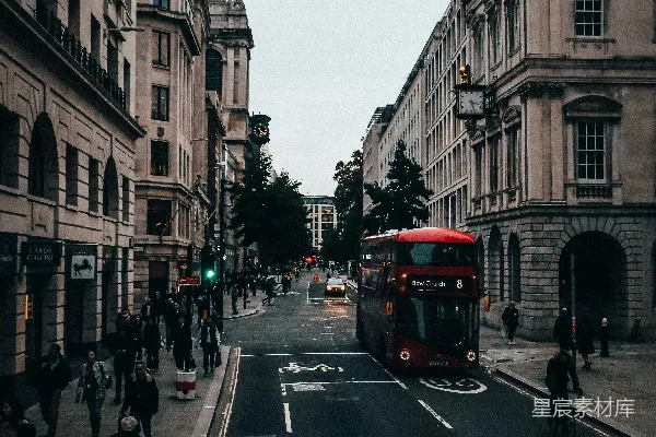 高清摄影 一辆红色的公交车沿着街道驶过，旁边是高楼大厦。