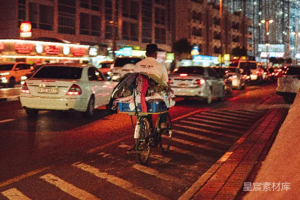 高清摄影 一个男人在夜晚街道上骑自行车。