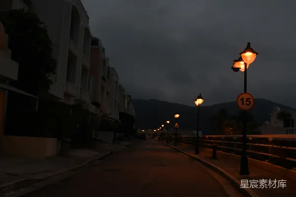 高清摄影 路灯在黄昏时分照亮了空荡荡的黑暗道路。