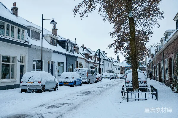 高清摄影 覆盖着雪的街道，停着汽车，两旁是房屋。