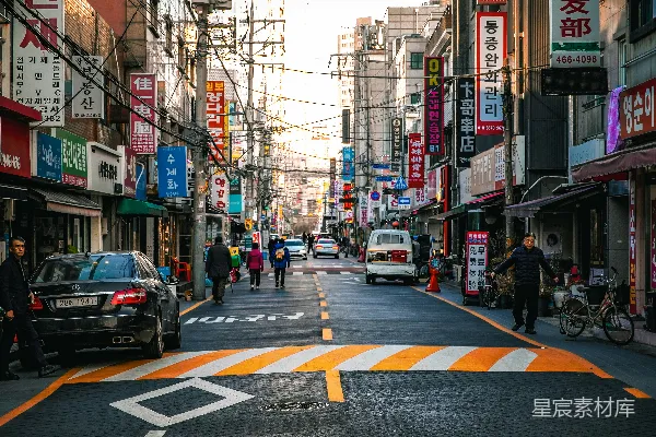 高清摄影 城市街道场景，有建筑物、路标、车辆和行人。
