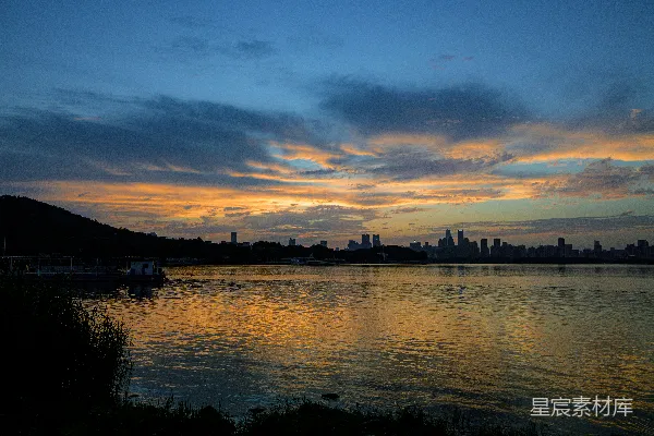 湖边的日落，背景是城市。