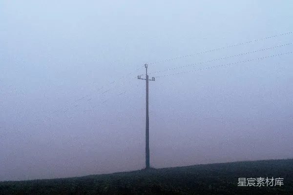 山间一棵在雾中隐约可见的电线杆