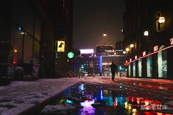 高清摄影 一个穿黑色夹克的男人在夜间街道上行走。