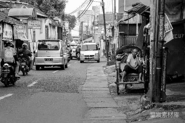 高清摄影 灰度摄影中，一名男子坐在椅子上，椅子靠近道路。