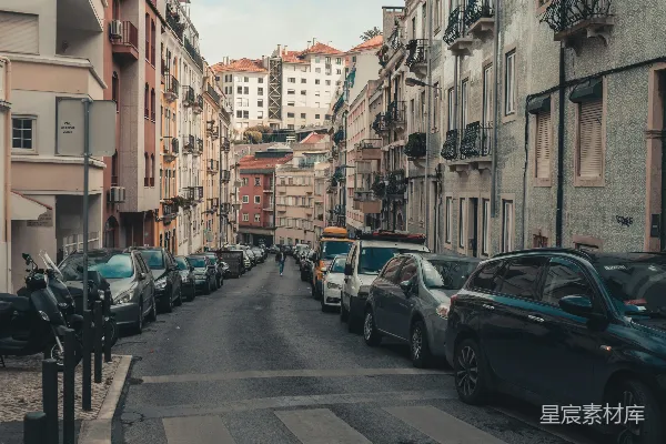 高清摄影 一条街道，两旁停着汽车，高大的建筑物矗立其间。