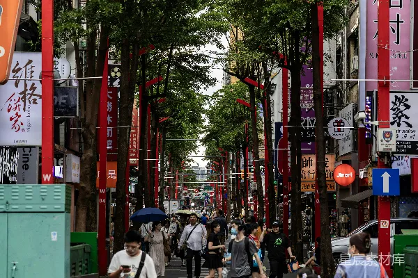 高清摄影 人们走在一条种满树木的街道上，街道上有红色的拱门。