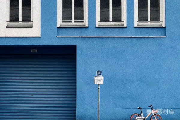 高清摄影 一辆自行车停在一栋蓝色建筑旁边。