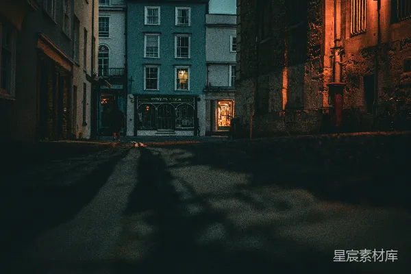 高清摄影 一条夜晚的黑暗街道，背景中有一座建筑物。