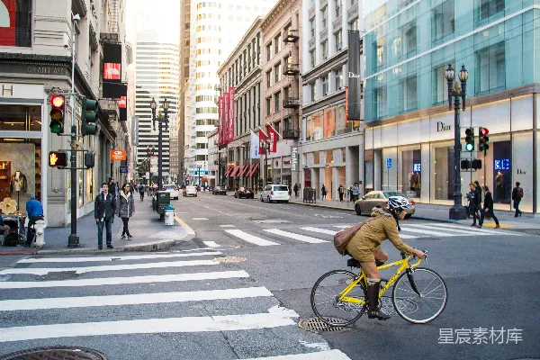 高清摄影 一个女人正在道路交叉口骑自行车。
