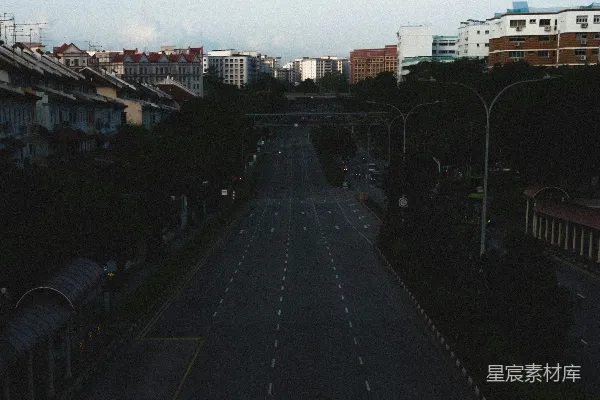 高清摄影 一条城市街道，两旁是建筑物和树木。