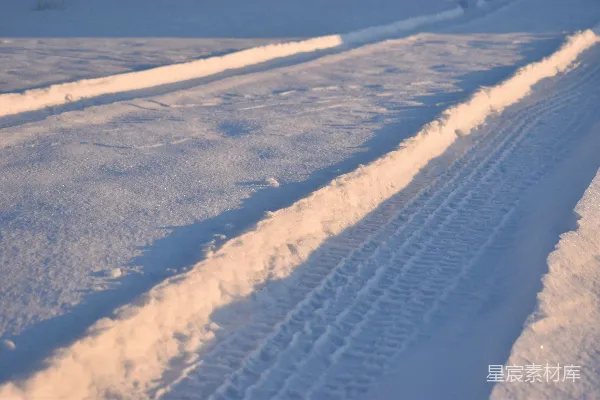 夕阳下的雪地车辙